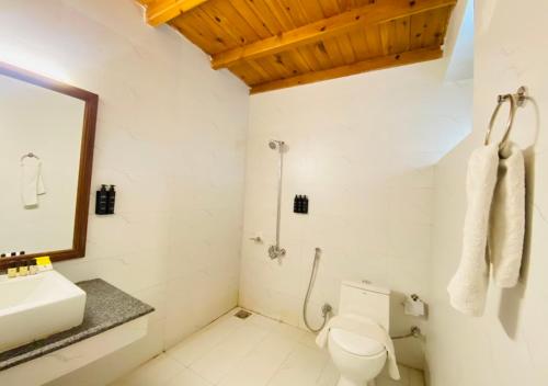 a white bathroom with a sink and a toilet at Destination Hotel Khaplu in Khaplu