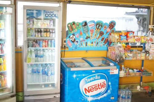 a refridgerator filled with lots of drinks at Sataya Apartment in Maha Sarakham
