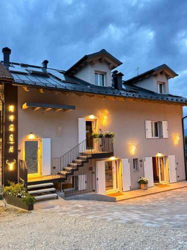 a white house with a staircase in front of it at Maso K - Il Gufo Dorato in Folgaria