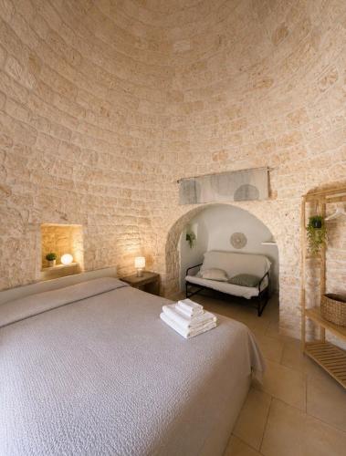 a bedroom with a large bed in a stone wall at Il trullo di Mattia in Noci