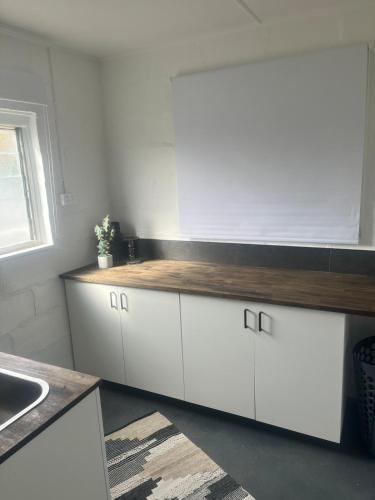 a kitchen with white cabinets and a wooden counter top at Olivers Home in Forbes