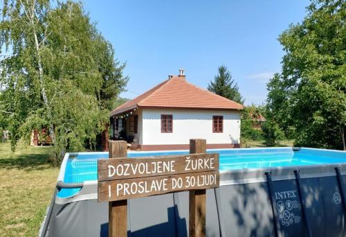 a sign on the back of a truck in front of a house at Tri breze Vodanj in Vodanj