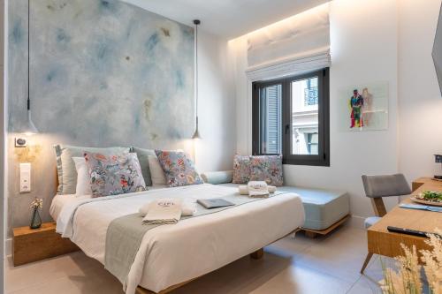 a bedroom with a large bed and a couch at Ciel Suites Athens in Athens