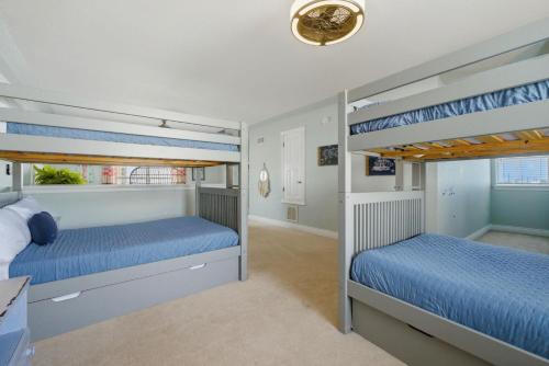 two bunk beds in a room with blue walls at Periwinkle Paradise in Navarre