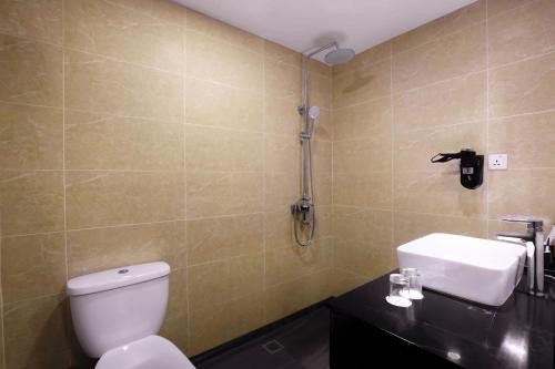 a bathroom with a toilet and a sink at du PALAIS Hotel in Sultan Thaha Airport