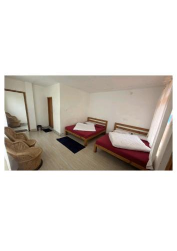 a room with two beds in a room at Ekdantam Hotel and Restaurant in Uttarkāshi