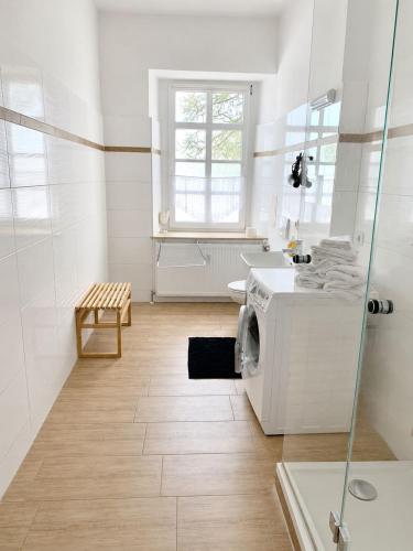 a white bathroom with a washer and dryer in it at Gut Rottmannshagen Mecklenburgische Seenplatte in Jürgenstorf