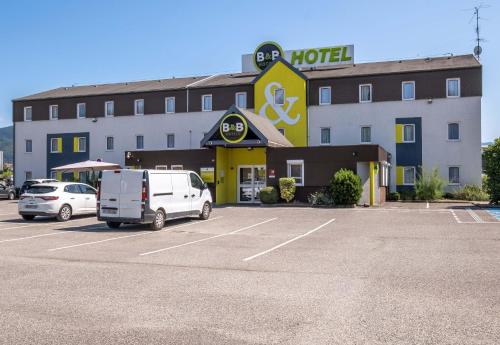 a hotel with a white van parked in a parking lot at B&B HOTEL Annecy Argonay in Argonay