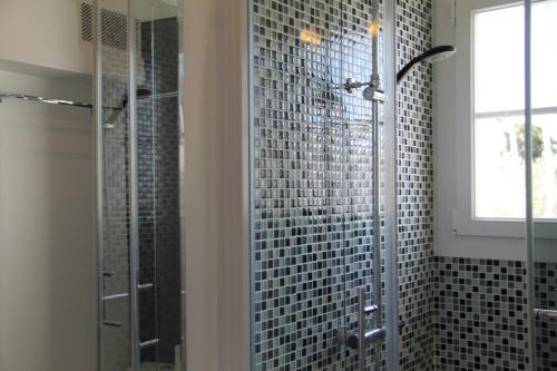 La salle de bains est pourvue d'une douche en verre et d'une fenêtre. dans l'établissement Beau T2 en centre ville avec parking privé, à Bandol