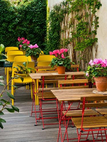 a row of tables and chairs with flowers on a deck at Borgo Vergini Garden B&B in Naples