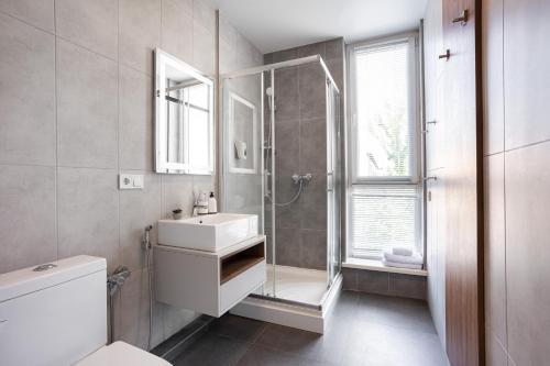 a bathroom with a toilet and a sink and a shower at Nyvky Like Home - Studio - apt 35 in Kyiv