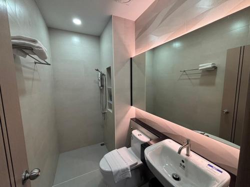 a bathroom with a sink and a toilet and a mirror at Jaroon House in Samutprakarn