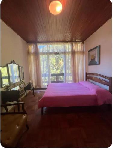 a bedroom with a large bed and a window at Quarto Iucas in Teresópolis