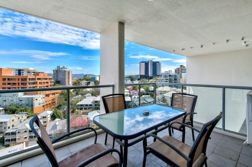 a balcony with a table and chairs and a view of the city at Flynn Brisbane in Brisbane