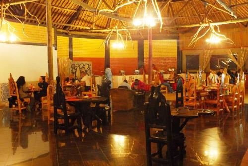 a restaurant with tables and people sitting at tables at Nature Haven Mara Camp in Ololaimutiek