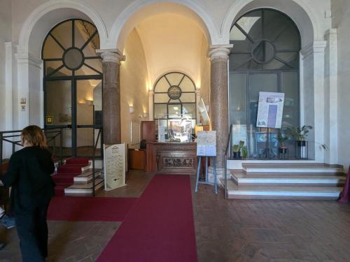 a woman walking through a building with a red carpet at Domus Sessoriana in Rome