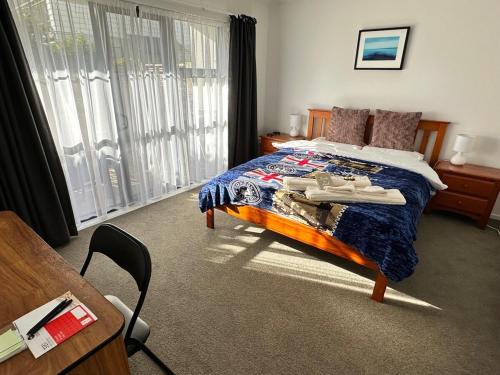 a bedroom with a bed and a table and a window at warm, quiet and convenient ! in Auckland