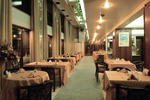 een rij tafels in een restaurant met wit linnengoed bij Yumukoglu Hotel in Izmir