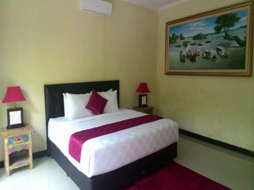 een slaapkamer met een groot bed en 2 tafels met lampen bij Terrace Bali Villa in Nusa Dua