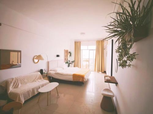 a bedroom with a bed and a couch and a table at Ek民宿 in Beihai