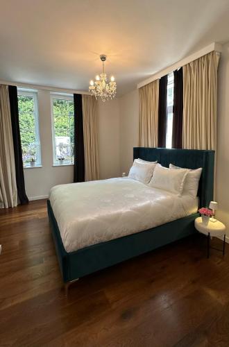 a bedroom with a large bed with a chandelier at Royal Horses in Overijse