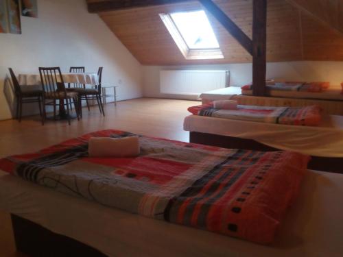 a room with three beds and a dining room with a table at Penzion U Slunce in Jaroměř