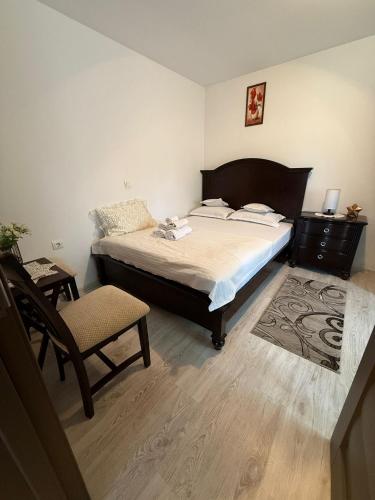 a bedroom with a large bed and a chair at Agropa Rooms & Garden Events in Bistriţa