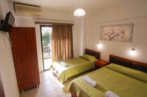 a hotel room with two beds and a window at Villa Herkules in Olympic Beach