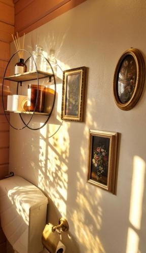 a bathroom with a toilet and three pictures on the wall at Amore in Chianti in Greve in Chianti