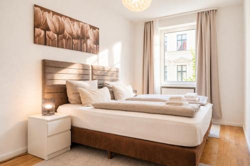 a white bedroom with a large bed with a window at URBAN FLATS Berlin in Berlin