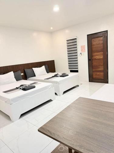 a room with two beds and a table at Reynaldos Place Corporation in Vigan