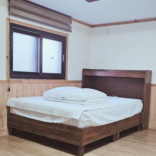 a large bed in a room with a window at Pyeonanhan Guesthouse in Hamdŏng-ni