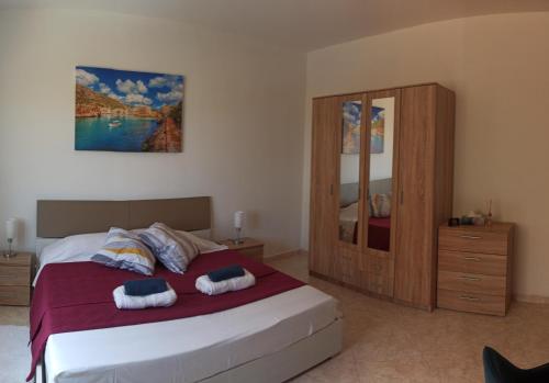 a bedroom with a bed and a wooden cabinet at GuestElia Gozo in Nadur