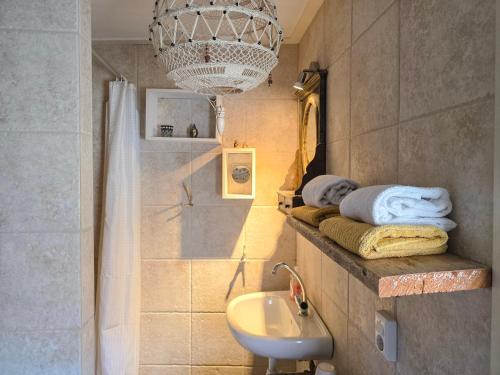 a bathroom with a sink and a chandelier at Vakantiewoning La Luna OK42 in Oostkapelle