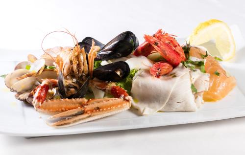 a plate of food with seafood on a white plate at Villa Corallium in Praiano