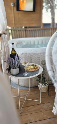 a table with a plate of food and a glass of wine at Mobile home Bokun sriće in Drage