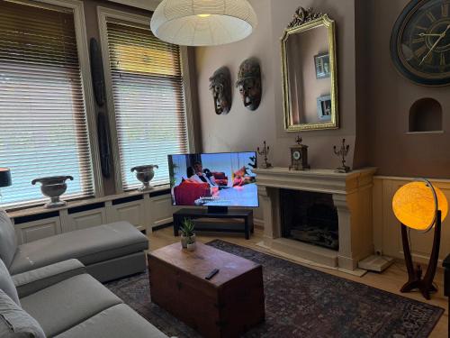 a living room with a tv and a fireplace at Grachtenpracht Boutique in Breda