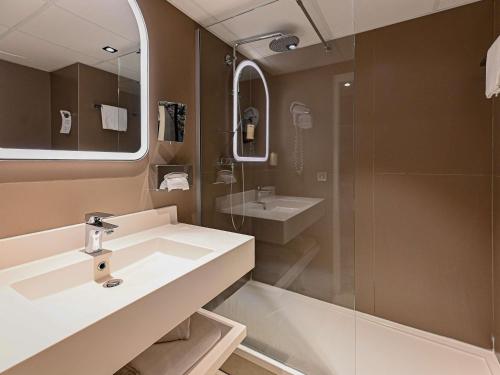 a bathroom with a sink and a shower at Hotel Mercure Blois Centre in Blois