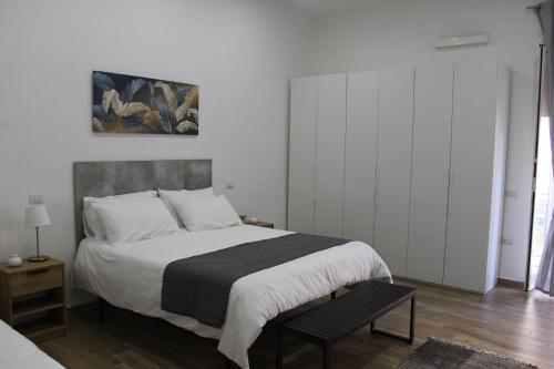 a white bedroom with a bed and a chair at Carpenters Guest House in Pompei
