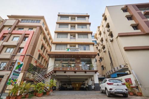 a building with a car parked in front of it at Treebo Premium PL Grand, Visakhapatnam in Visakhapatnam