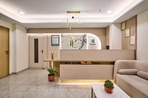 a lobby with a reception desk and a couch at Treebo Premium PL Grand, Visakhapatnam in Visakhapatnam