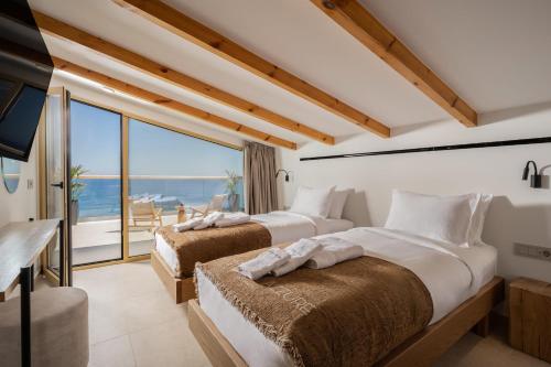two beds in a room with a view of the ocean at Callisto Azzure in Zakynthos