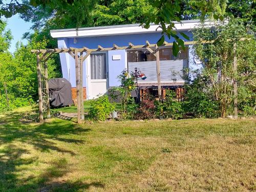 a small house with a gazebo in a yard at Bungalow Koje in Kröslin