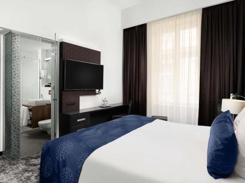a hotel room with a bed and a television at Nemzeti Hotel Budapest - MGallery Collection in Budapest