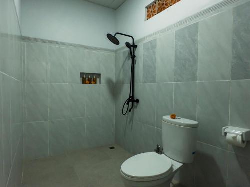 a bathroom with a white toilet and a shower at JERO Tabola 2 in Sidemen