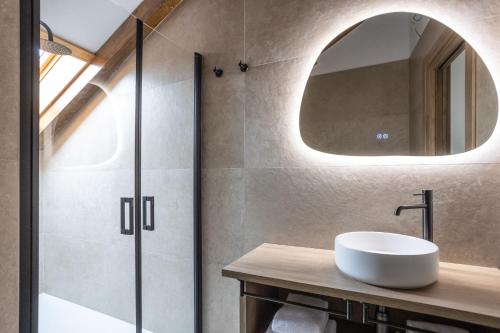 a bathroom with a sink and a mirror at Hotel Truita in Cangas del Narcea