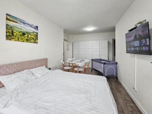 a bedroom with a white bed and a table at Konstanzer 103 - 2 Room Ap & Parking- Iulius Mal - Smart TV - Highspeed Wi-Fi in Iaşi