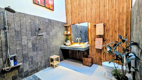a bathroom with a sink and a toilet and a mirror at Cargo Remote Mui Ne in Phan Thiet
