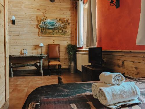 a bedroom with a bed and a desk with a television at La Posada Cercedilla in Cercedilla