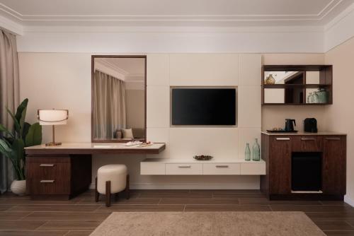 a living room with a television and a desk at SRNTY Sahl Hasheesh - Ex Serenity Sky Arc in Hurghada